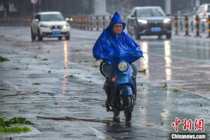 圖為海口市民冒雨出行?！●樤骑w 攝