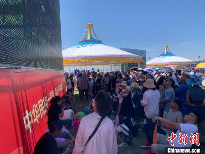 圖為沒有擠進(jìn)座位席的人們，在會場一側(cè)的大屏幕下觀看演出。　奧藍(lán) 攝