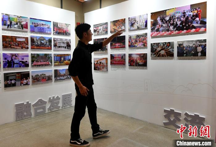 來(lái)自臺(tái)灣桃園的“80后”音樂(lè)人張家豪正在參觀圖片展?！蚊?攝