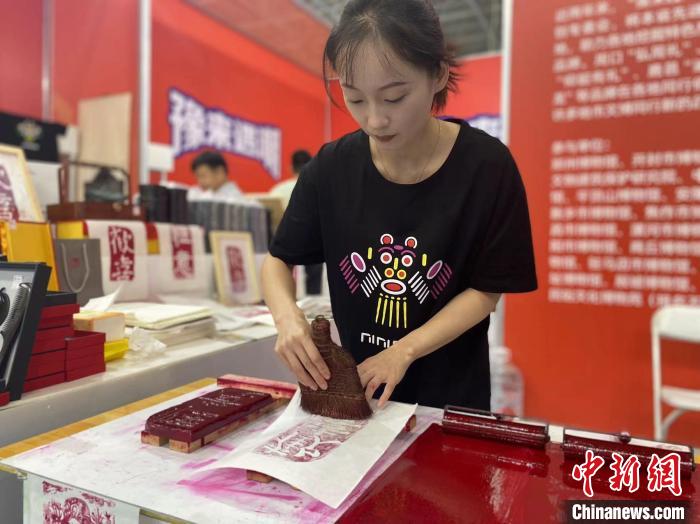 7月14日，周口華威民俗文化博物苑的講解員杜奧杰在文博會(huì)現(xiàn)場(chǎng)展示拓印。中新社記者張瑋攝