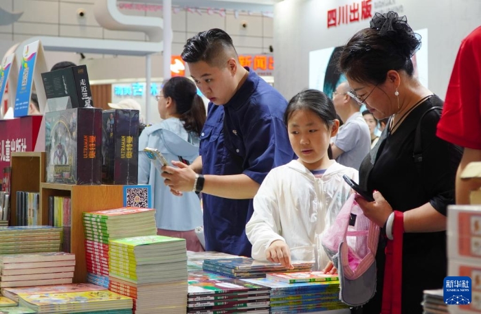 7月27日，在第31屆全國圖書交易博覽會上，讀者在閱覽新書。新華社記者 徐速繪 攝