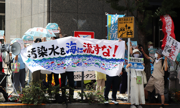 8月24日，日本民眾手持“不許將污染水排入大海”等標語在東京電力公司總部前集會，抗議日本政府和東電公司無視民意啟動核污染水排海。（圖源：新華網）