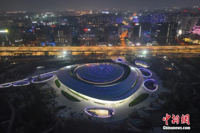 資料圖：杭州2022年亞運(yùn)會(huì)電子競(jìng)技場(chǎng)館入夜亮燈，屋頂彩色光條如星軌。(無人機(jī)照片) 中新社記者 王剛 攝