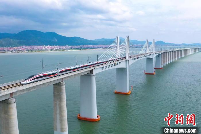 9月28日，復(fù)興號智能動車組行駛在福廈高鐵湄洲灣跨海大橋。歷經(jīng)6年多時間建設(shè)，全長277公里的福廈高鐵，穿越多處山脈，跨越多處海灣，將難上九重天的閩道與大海緊緊相連。李響攝