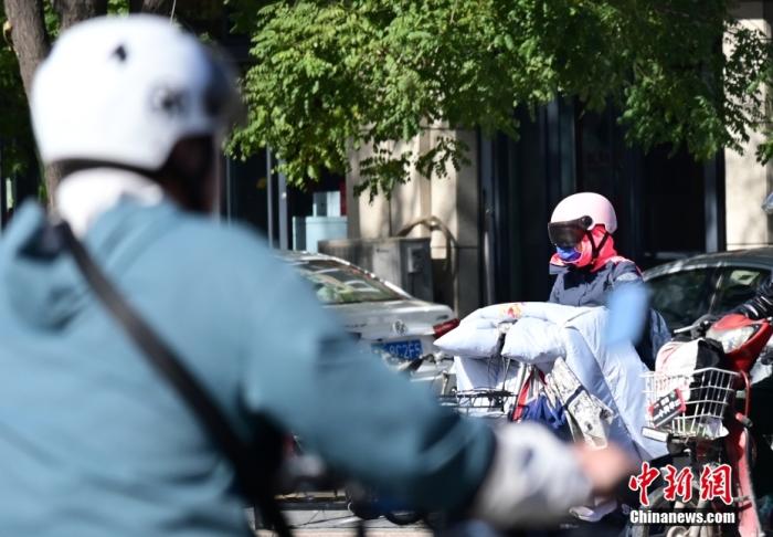 石家莊街頭，市民紛紛穿上厚厚的外套“捂”裝前行。 <a target='_blank' href='/'>中新社</a>記者 翟羽佳 攝
