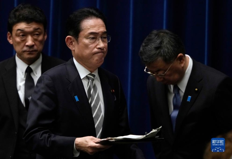 12月13日，日本首相岸田文雄（中）在日本東京首相官邸召開(kāi)記者會(huì)后走過(guò)內(nèi)閣官房長(zhǎng)官松野博一（右）。（圖源：新華社）