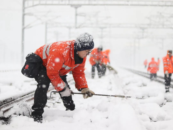 工作人員對(duì)鐵路道岔采取除雪等措施。