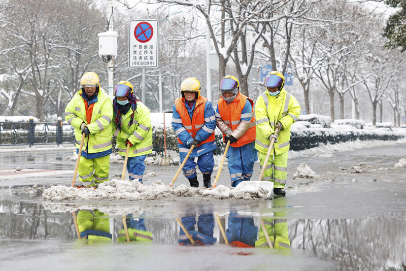 2月4日，在江蘇省宿遷市泗洪縣泗州大街，工作人員在清掃路面積雪。（圖源：新華社）