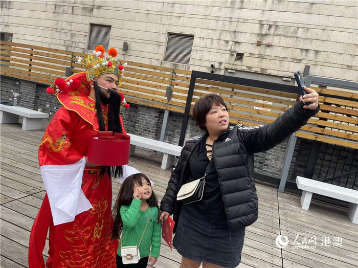 圖為送出吉祥如意的財神與游客合影。人民網(wǎng)記者 富子梅攝
