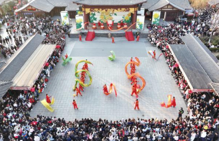 春節(jié)假期，各地紛紛“亮家底”“出大招”，舉辦豐富多彩的文旅活動，吸引市民和游客參觀游覽，體驗十足年味。圖為日前，游客在河南省開封市清明上河園景區(qū)觀看表演。新華社發(fā)（譚豫增 攝）