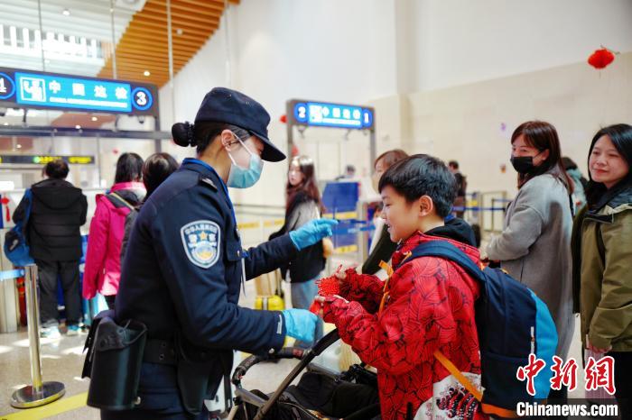 2月10日，福州出入境邊防檢查站移民管理警察向入境臺胞贈送中國結(jié)。　楊馨 攝