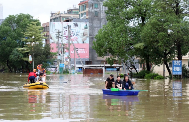 4月21日，廣東清遠(yuǎn)英德市浛洸鎮(zhèn)居民在積水的道路上乘船出行。新華社記者 黃國(guó)保 攝