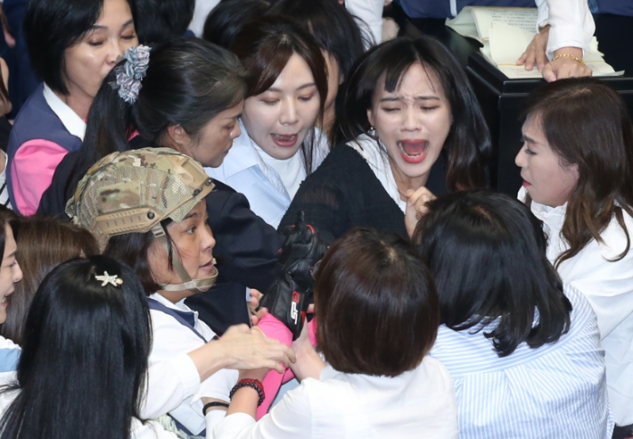 民進(jìn)黨立委黃捷（中右）等人想趁國民黨放松防備之際突襲，與國民黨立委陳玉珍（中左）發(fā)生拉扯沖突