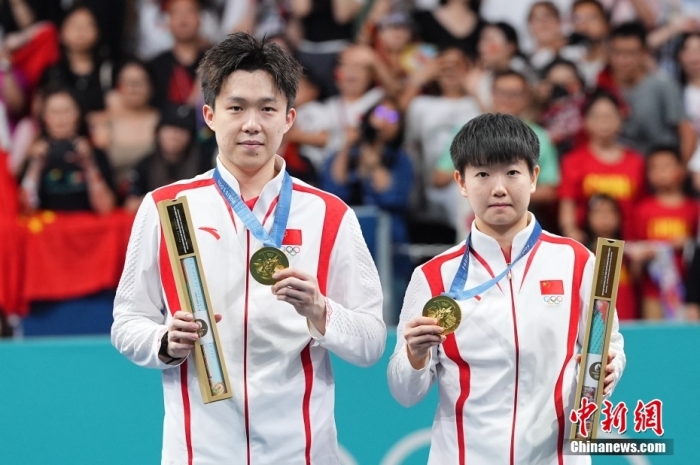 當?shù)貢r間7月30日，在巴黎奧運會乒乓球混合雙打決賽中，中國組合王楚欽/孫穎莎以4比2戰(zhàn)勝朝鮮組合李正植/金琴英，為中國乒乓球隊奪得本屆奧運會乒乓球項目首金，同時這也是中國乒乓球隊在混雙項目上的奧運首金。圖為王楚欽(左)和孫穎莎在頒獎儀式上。<a target='_blank' href='/'>中新社</a>記者 趙文宇 攝