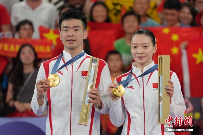 當(dāng)?shù)貢r(shí)間8月2日，在巴黎奧運(yùn)會(huì)羽毛球混合雙打決賽中，中國組合鄭思維/黃雅瓊以2-0勝韓國組合金元昊/鄭娜銀，獲得金牌。圖為頒獎(jiǎng)儀式上，鄭思維/黃雅瓊（右）展示金牌。<a target='_blank' href='/'>中新社</a>記者 趙文宇 攝